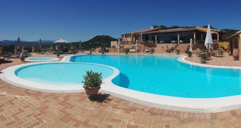 Vista panoramica della piscina con idromassaggio e l'edificio dell'hotel