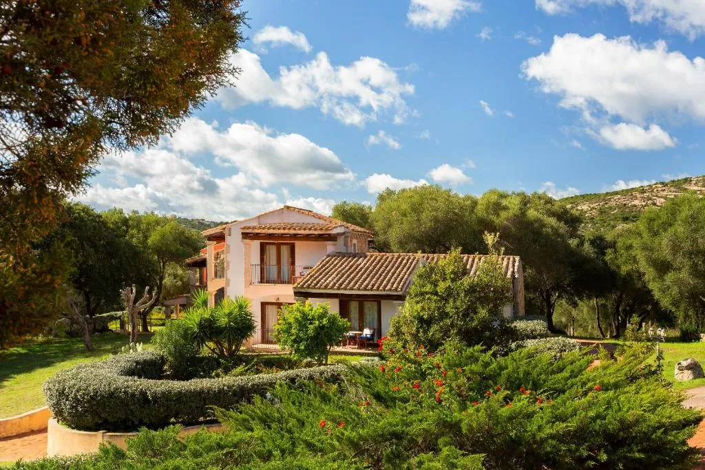 Edificio in stile sardo immerso nel verde con giardino curato e ulivi