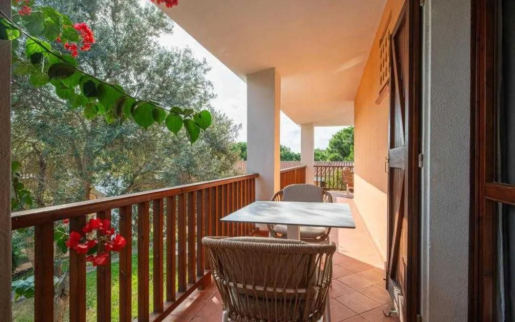 Balcone con tavolo e sedie affacciato sul giardino con fiori