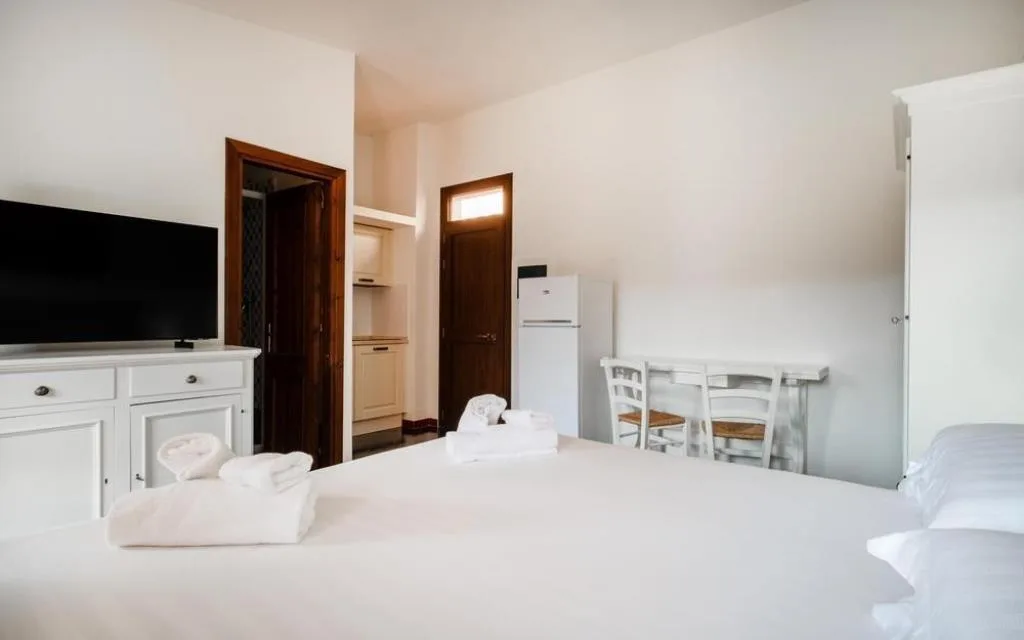 Monolocale con letto, TV, angolo cottura e tavolo da pranzo