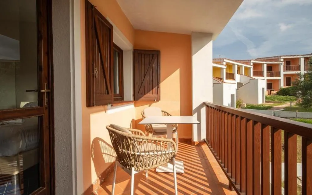Balcone con tavolo e sedie e vista sul residence