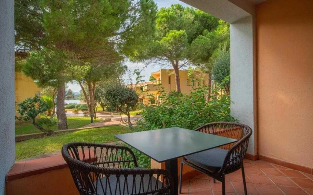 Veranda con tavolo e sedie affacciata sul giardino e alberi