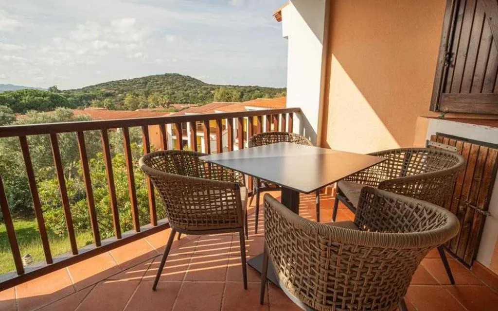 Balcone con tavolo e sedie in vimini e vista panoramica sulle colline