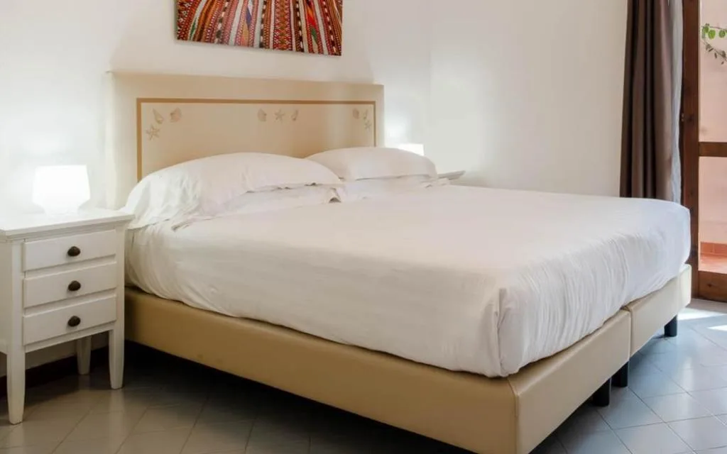 Camera matrimoniale con letto bianco e comodino