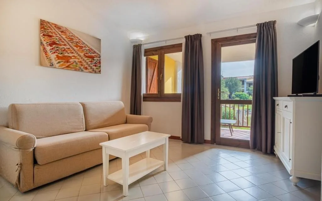 Soggiorno con divano, TV e accesso al balcone