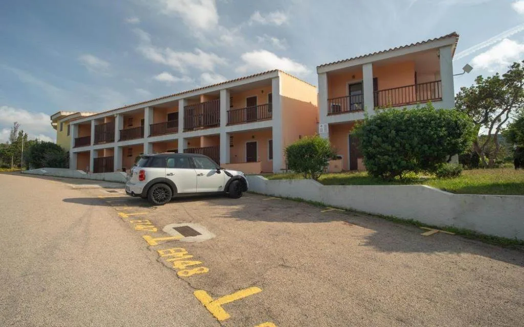 Esterno del residence con parcheggio e edifici a due piani