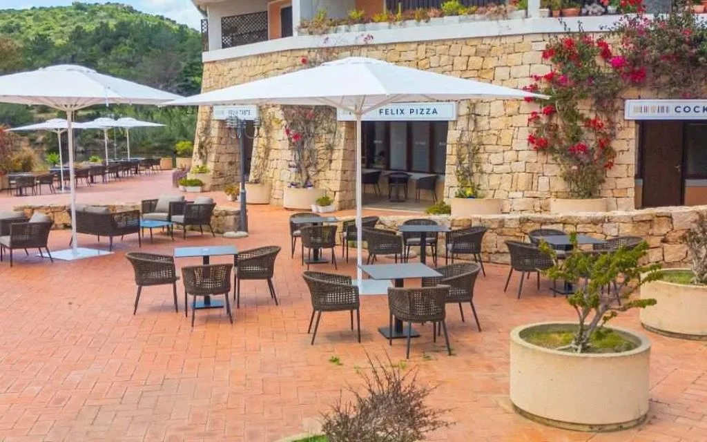 Area esterna con pizzeria, tavoli, sedie e ombrelloni