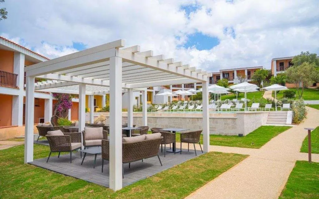 Pergola bianca con lounge e vialetto nel giardino del resort