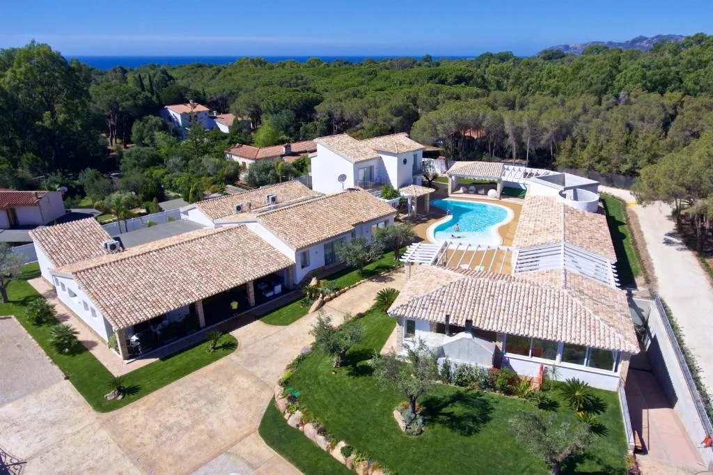 Vista aerea del resort con ville, piscina e vista mare in lontananza