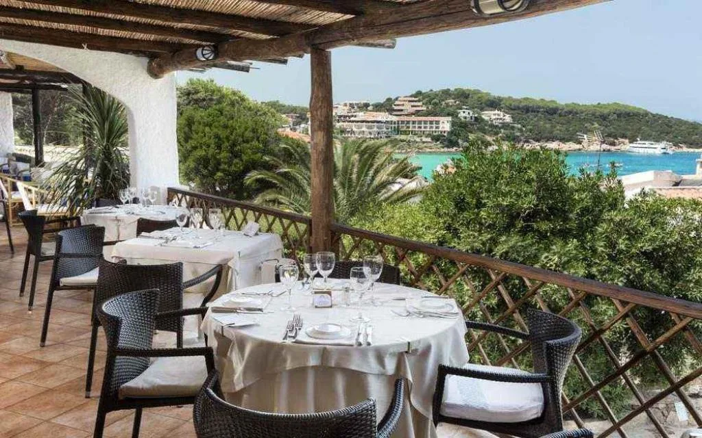 Tavoli del ristorante su terrazza panoramica con vista sulla baia