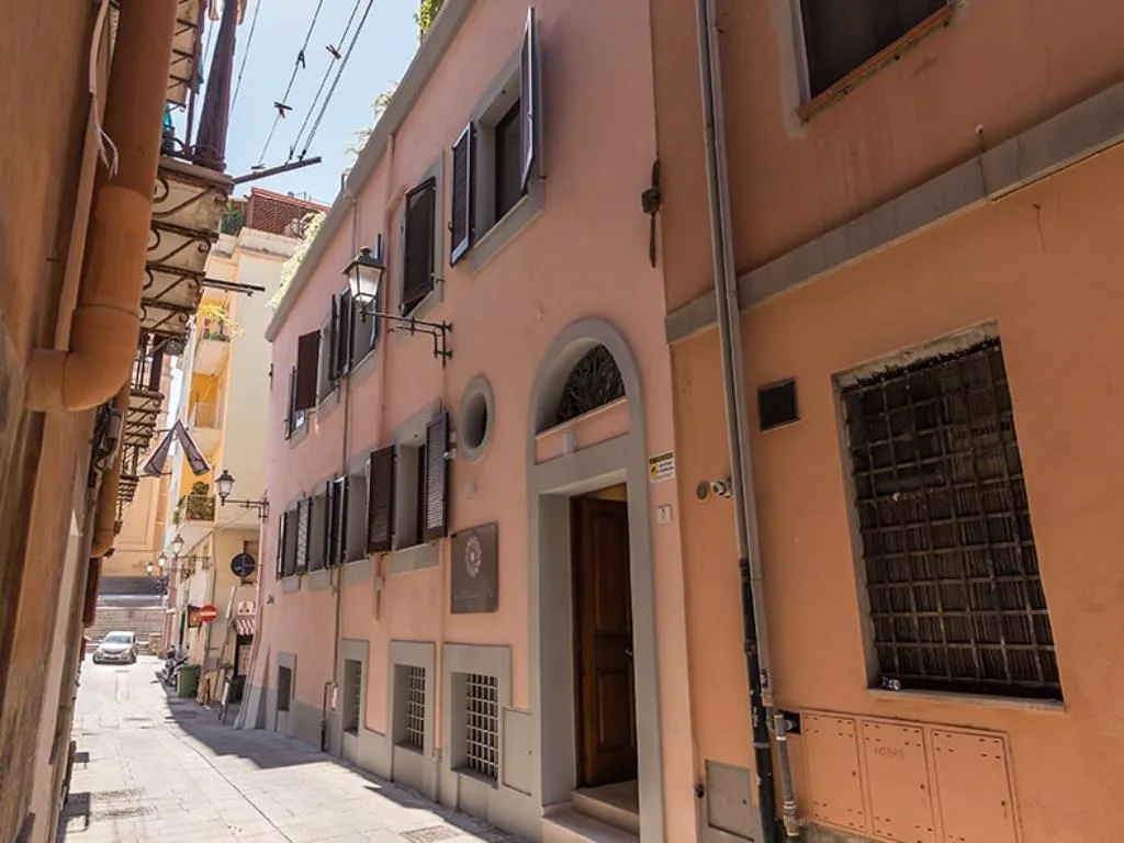 Facciata rosa dell'edificio in un vicolo storico del centro con ingresso ad arco