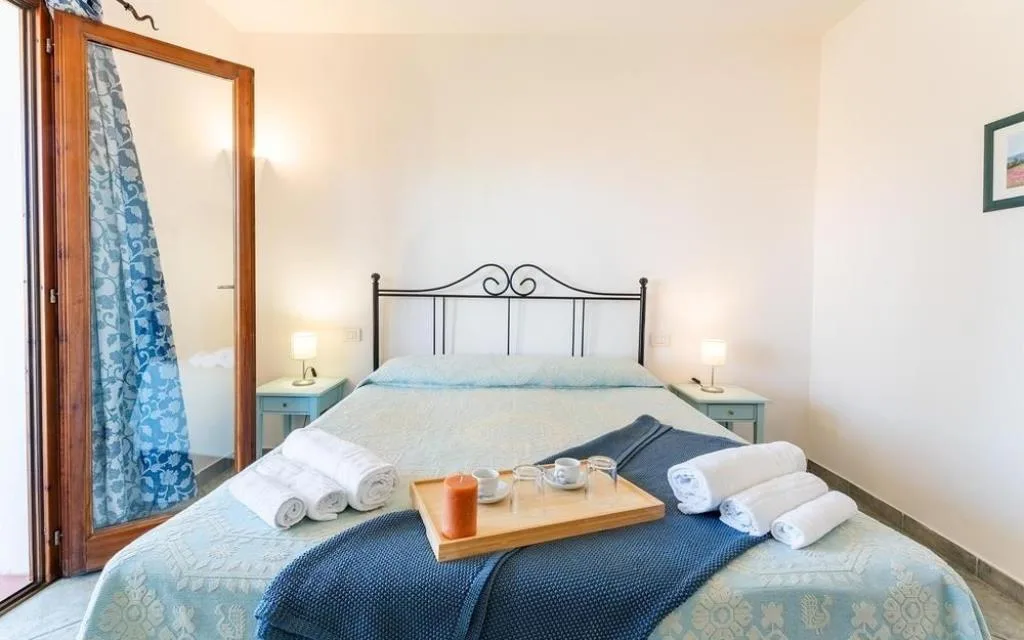 Camera da letto con letto matrimoniale, specchio e vassoio con asciugamani