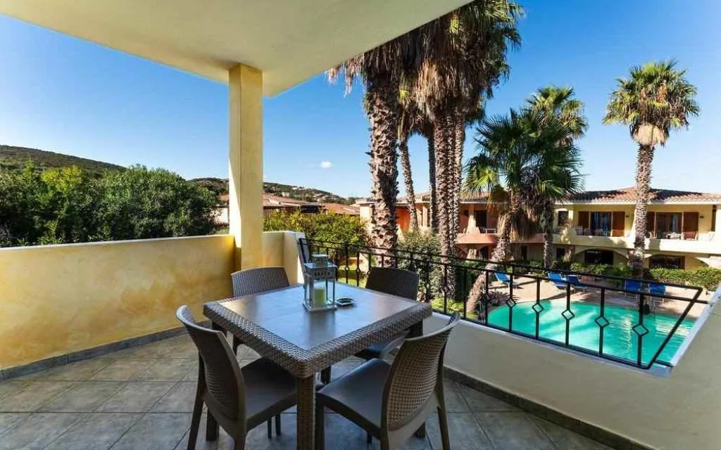 Balcone con tavolo da pranzo e vista sulla piscina e sulle colline