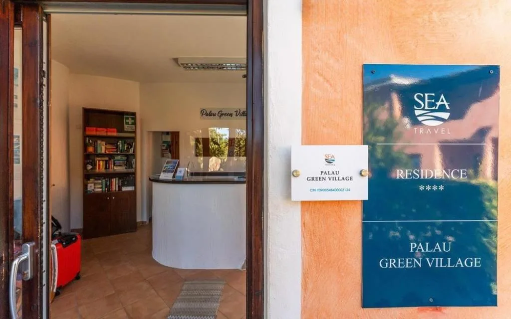 Reception del Residence Palau Green Village con insegna Sea Travel