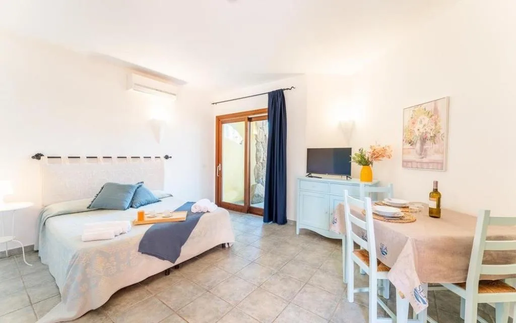 Monolocale con letto matrimoniale, TV, credenza e tavolo da pranzo