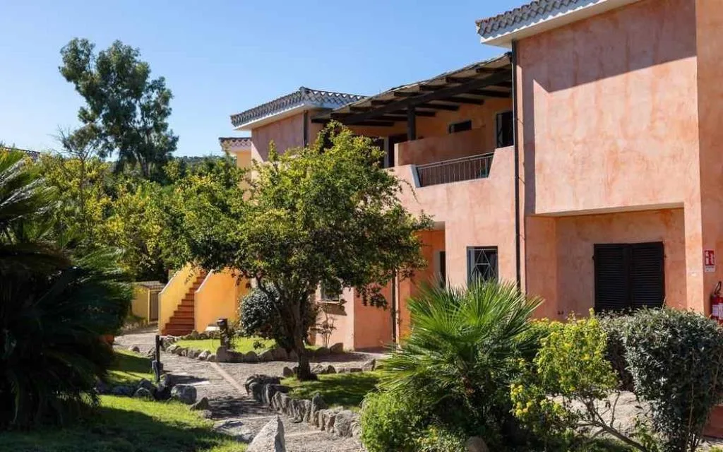 Esterno degli edifici color pesca del residence circondati da giardino